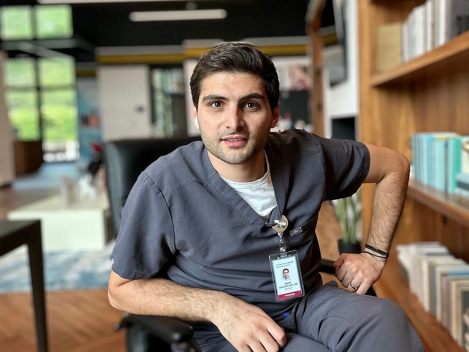David Maglakelidze, MD, seated in a quiet office lined with bookshelves